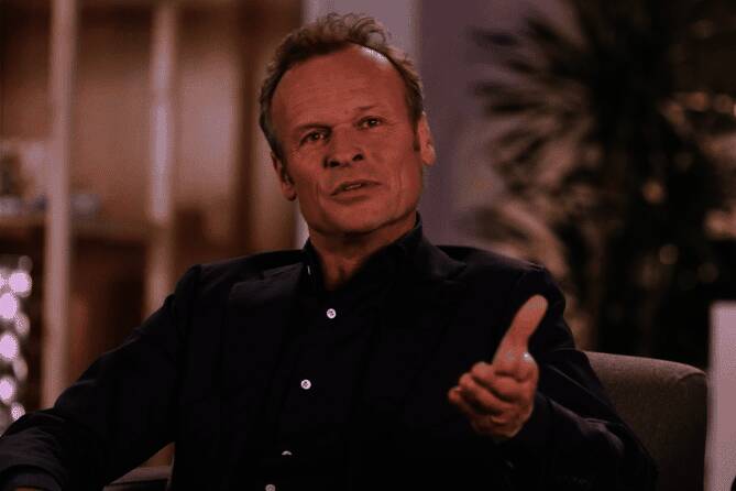 PlayStation高层出席投资者炉边谈话现场，胡尔斯特发言神情专注，背景为PS5产品展示