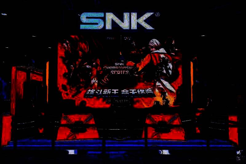 SNK展台全景，灯光璀璨，人流如织