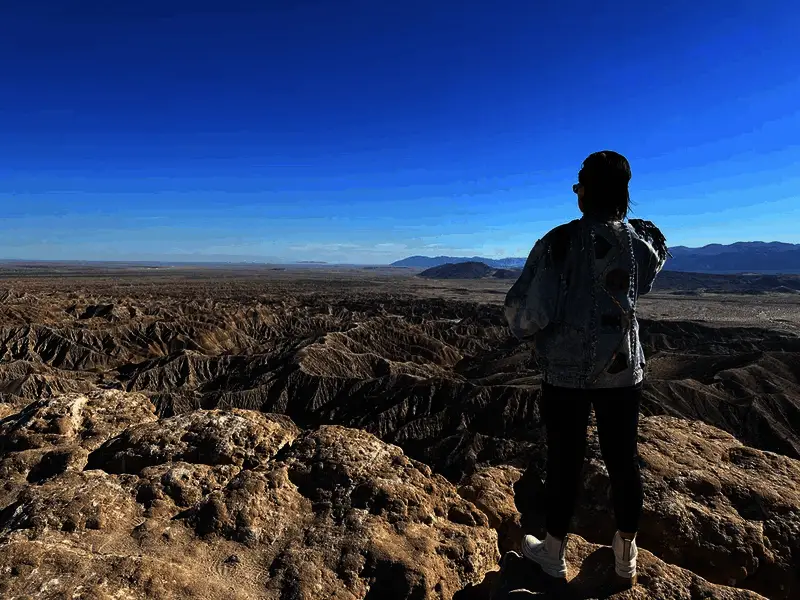 玩家角色在沙漠中行走的特写镜头，光影与纹理处理极为细腻