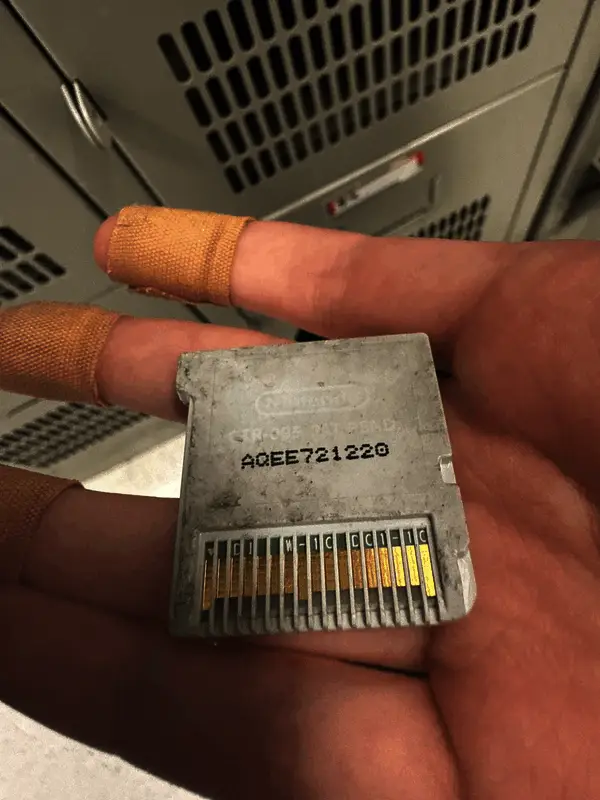 破损严重的《塞尔达传说：时之笛3D》卡带正面特写，外壳裂痕明显