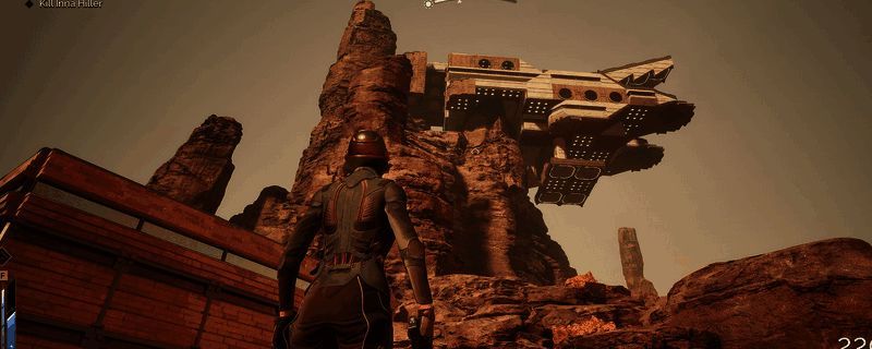 《沙丘：觉醒》游戏中玩家角色在沙漠中行走，远处可见交易站建筑