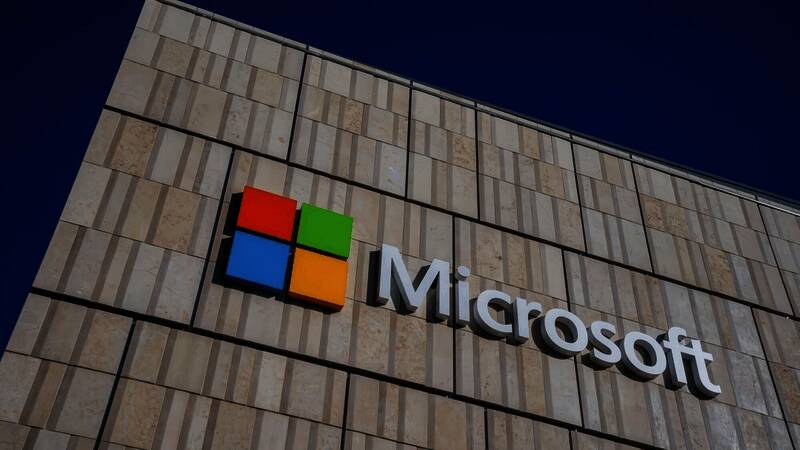 微软总部大楼外景，玻璃幕墙反射着阳光，象征科技企业的冷峻与理性