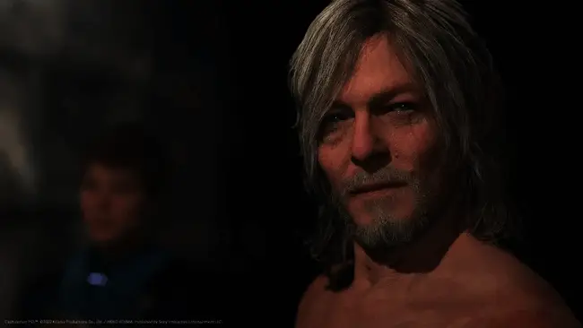 小岛秀夫在活动现场与嘉宾合影，背景为《死亡搁浅2》主题布置