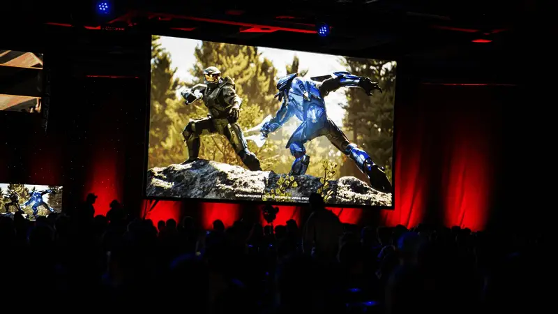 Halo Studios团队成员讨论项目细节，背景显示虚幻5引擎界面