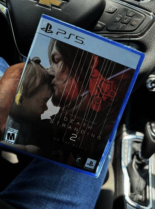 玩家手持《死亡搁浅2》实体版照片，展示游戏外包装正面设计