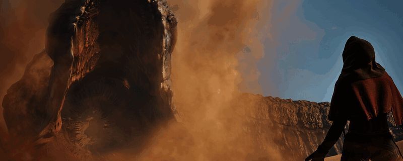 《沙丘：觉醒》中巨型沙虫破沙而出的震撼画面，黄沙飞舞，场景极具压迫感