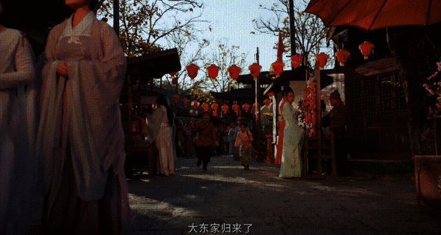 商队归来的街头盛况，人群簇拥，场面宏大，氛围浓厚