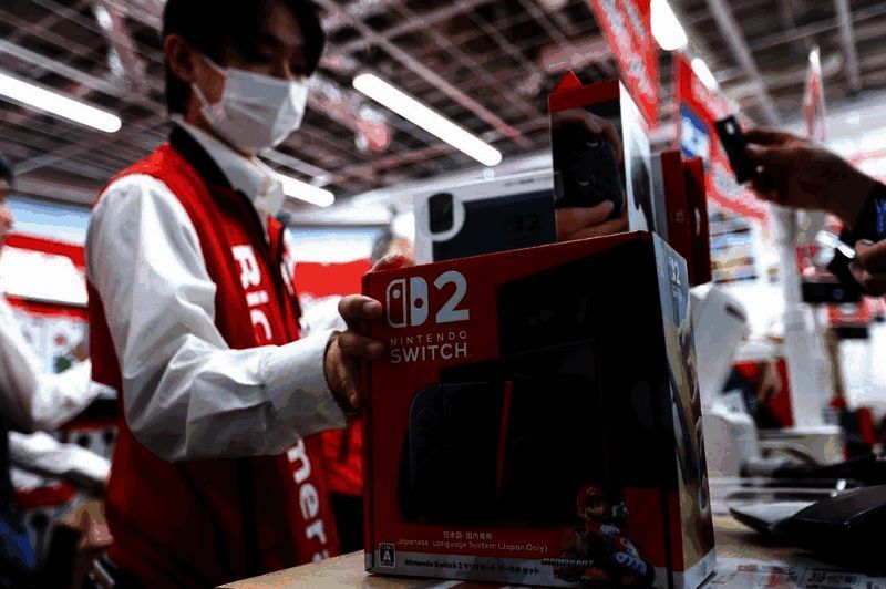 主播拉斐尔手持Switch 2主机进行评测的画面，背景为工作室环境