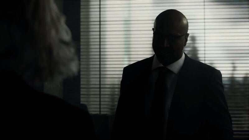 艾丽莎在深夜独自驾车逃离浣熊市，后视镜中可见远处爆炸火光