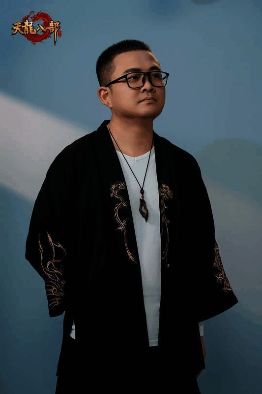 裂天舞台演出照，背景灯光炫目，他身穿黑色风衣，神情专注演唱