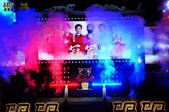 比赛现场气氛紧张，选手专注操作，屏幕显示激烈攻防画面