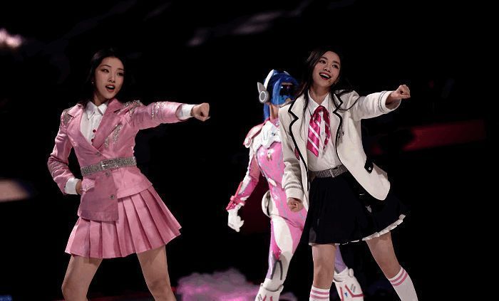 女团成员身穿炫酷皮肤舞台表演，灯光璀璨，气氛高涨