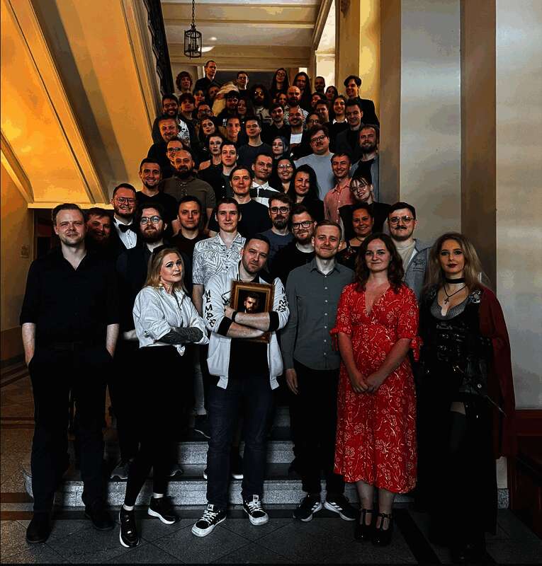 开发团队核心成员正在电脑前进行调试，背景墙上贴满项目进度图表