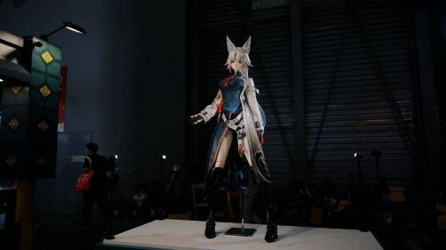 三人合力抬起巨斧模型，背景可见围观玩家的惊讶表情