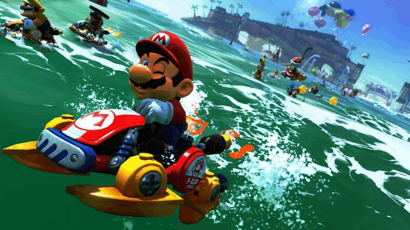 任天堂高层接受采访现场画面，背景展示《马里奥赛车：世界》游戏界面