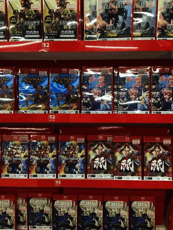 玩家围观展示架并用手机拍摄游戏封面，现场气氛热烈，讨论声不断