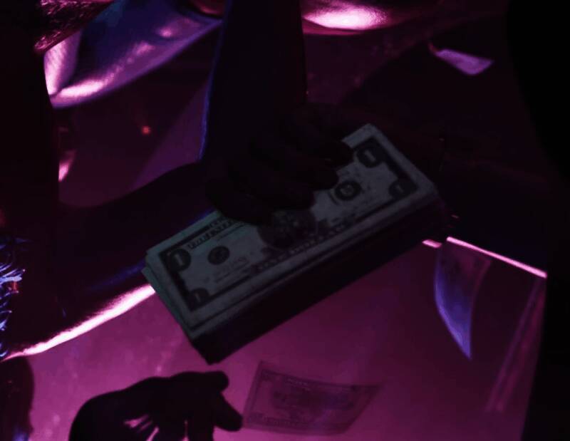 《GTA6》脱衣舞俱乐部环境细节截图，背景人物与装饰高度还原现实风格