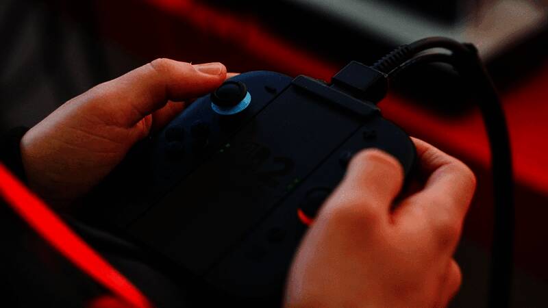 Claire手持ROG Ally掌机，桌面摆放着Switch及多款游戏光碟