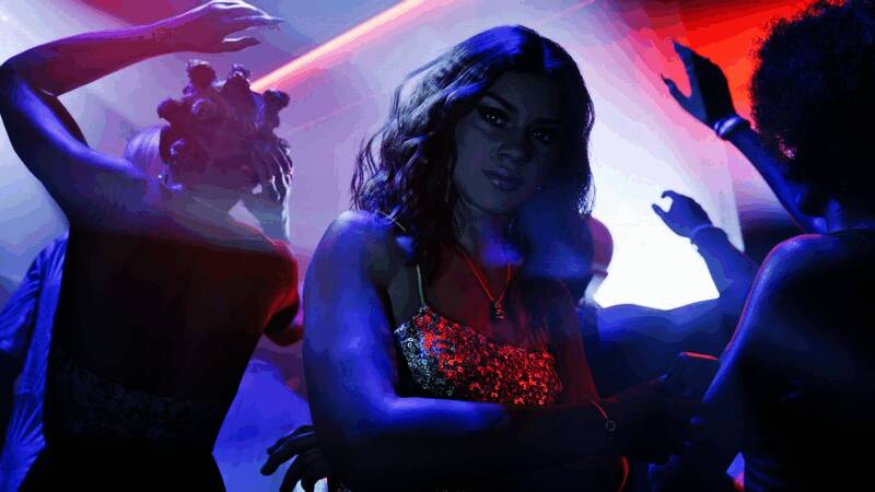 露西亚与杰森在车内密谋计划，周围布满地图和武器