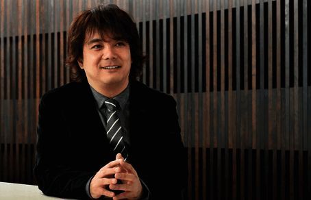 Level5社长接受采访现场画面，背景为公司标志性游戏IP海报墙