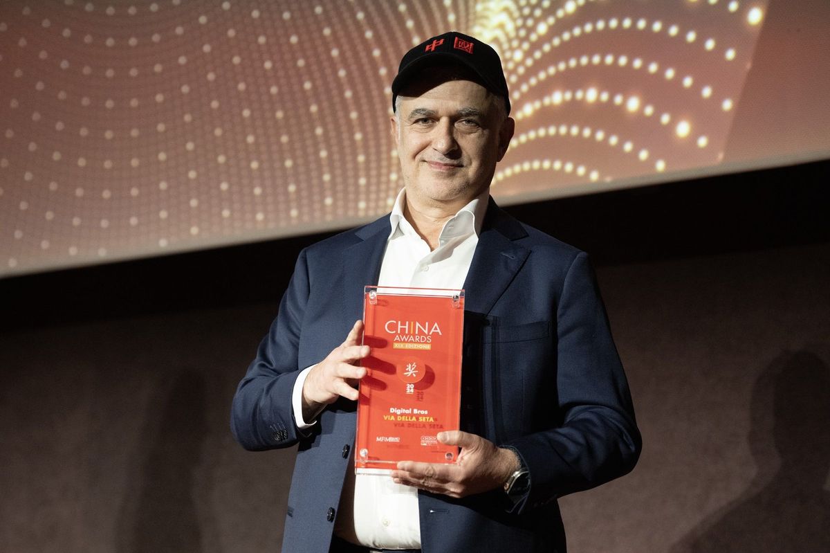 Digital Bros代表在米兰科技博物馆领取‘丝绸之路2024’大奖的现场照片，背景为古典建筑与灯光装饰