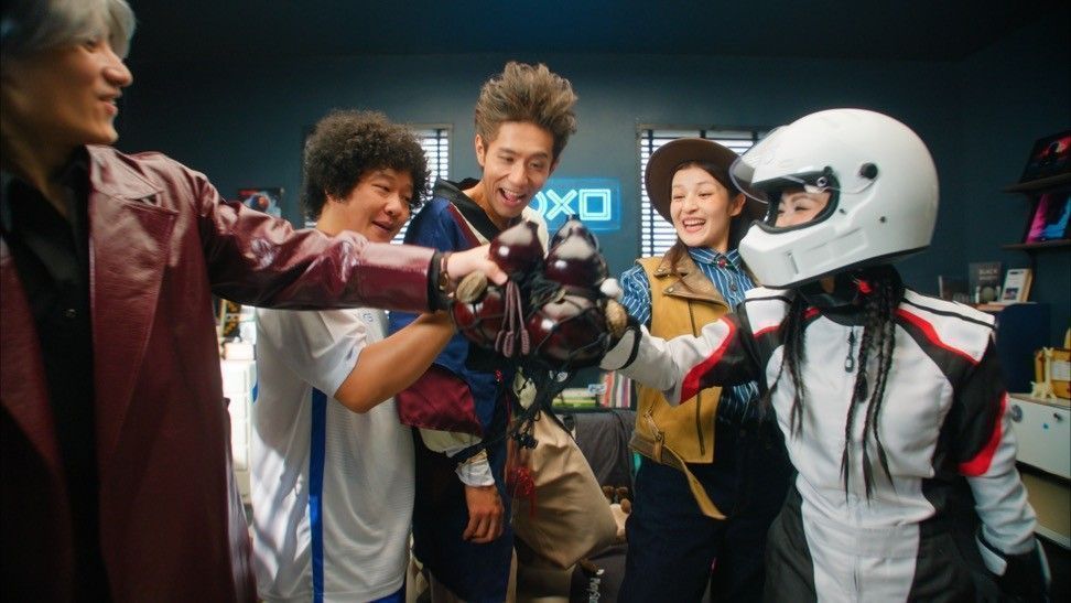 PS5主机与多款游戏光盘陈列展示，周围环绕着玩家互动画面投影