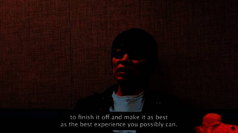 滨口直树在采访中的截图，面带微笑坐在镜头前，身后是《最终幻想7：重生》的官方艺术海报