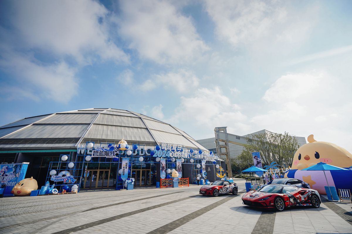 玩家与Coser在滑梯前合影，背景是蓝天白云布景