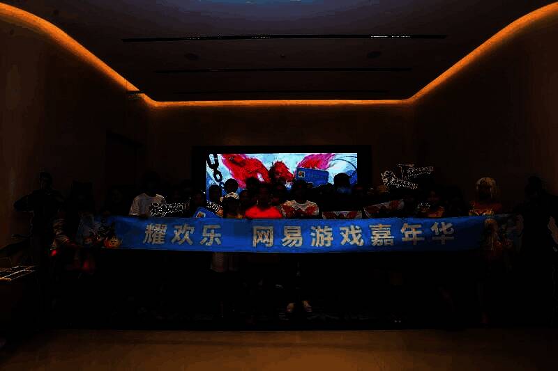 荣耀门店内玩家参与多种游戏互动项目，工作人员引导体验，整体布局科技感十足