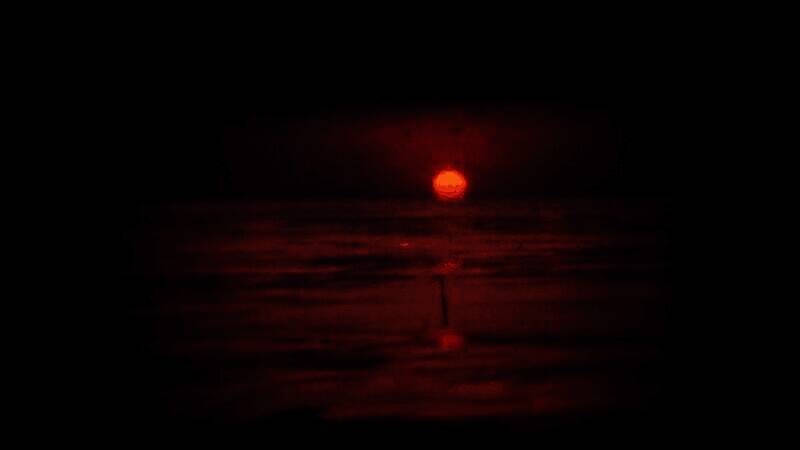 预告片截图：昏黄灯光下的旧式电话亭，玻璃上倒映着模糊人影，充满孤独感