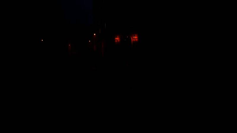 主角手持老式步枪在雪地城镇中潜行，远处有外星三足机甲巡逻