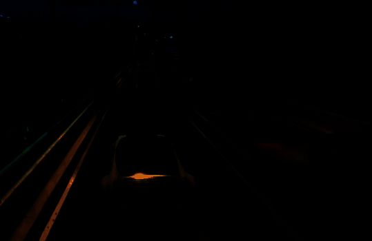 一辆黑色仿赛摩托车停在暗巷中，车身线条锋利，灯光闪烁，充满攻击性