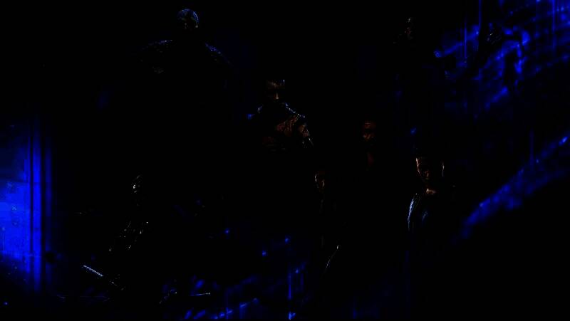 PlayStation音乐会概念图，舞台上交响乐团演奏中，背景是《最后生还者》《战神》等游戏场景的光影交错