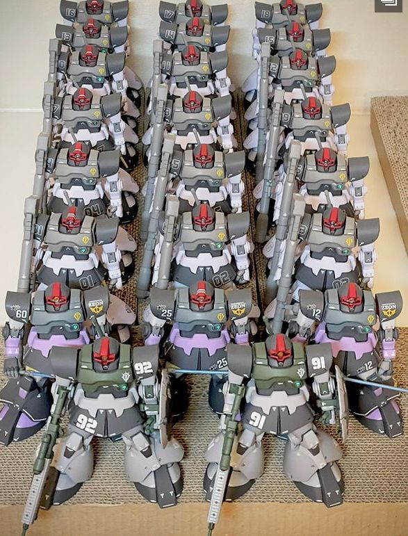 多台里克·大魔模型在灯光照射下展示背部推进器与武器细节，整体呈现科幻战场氛围