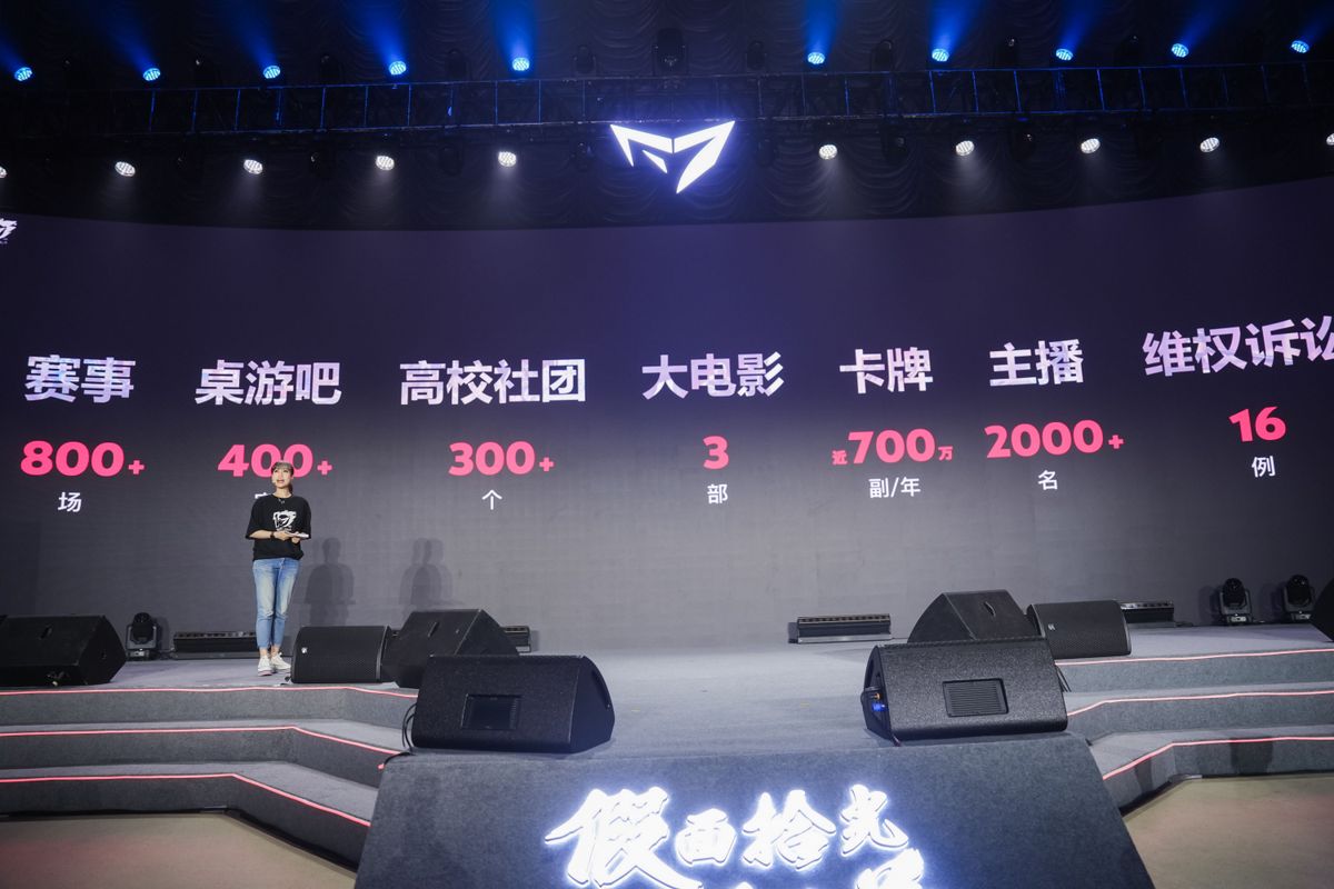 狼人杀赛事现场，选手佩戴耳机激烈辩论，观众席座无虚席