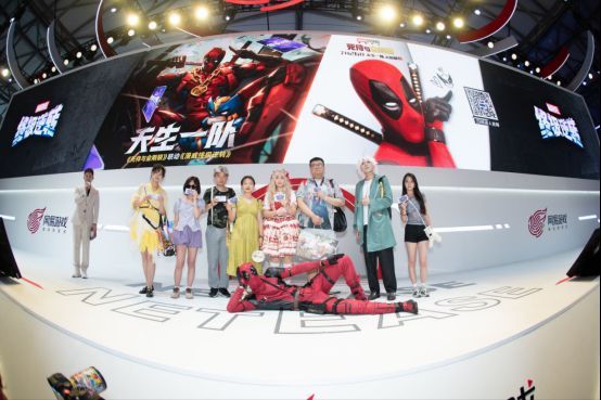 扮演死侍的演员走上舞台与主持人互动，现场玩家兴奋拍照