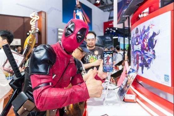 死侍扮演者在试玩区体验《漫威终极逆转》，手持平板专注操作