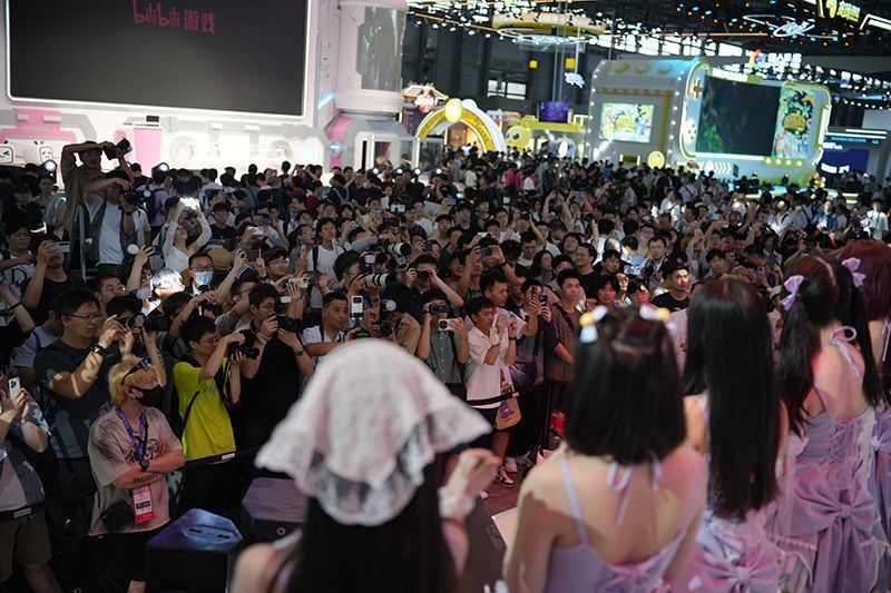 玩家在试玩区排队等候，工作人员引导有序