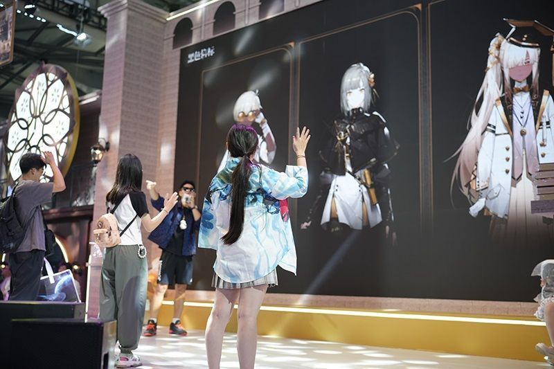 工作人员为玩家发放纪念品，现场秩序井然