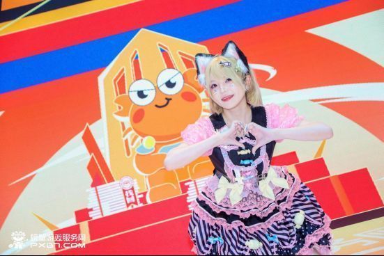 UP主欣小萌在舞台上表演萌舞，笑容甜美，动作可爱，观众热烈鼓掌