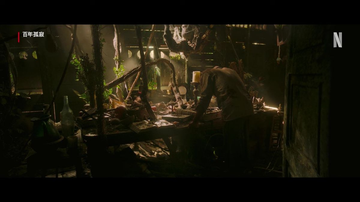 马康多小镇全景，绿意环绕的河畔村落，房屋错落有致，天空泛着微光，充满神秘氛围