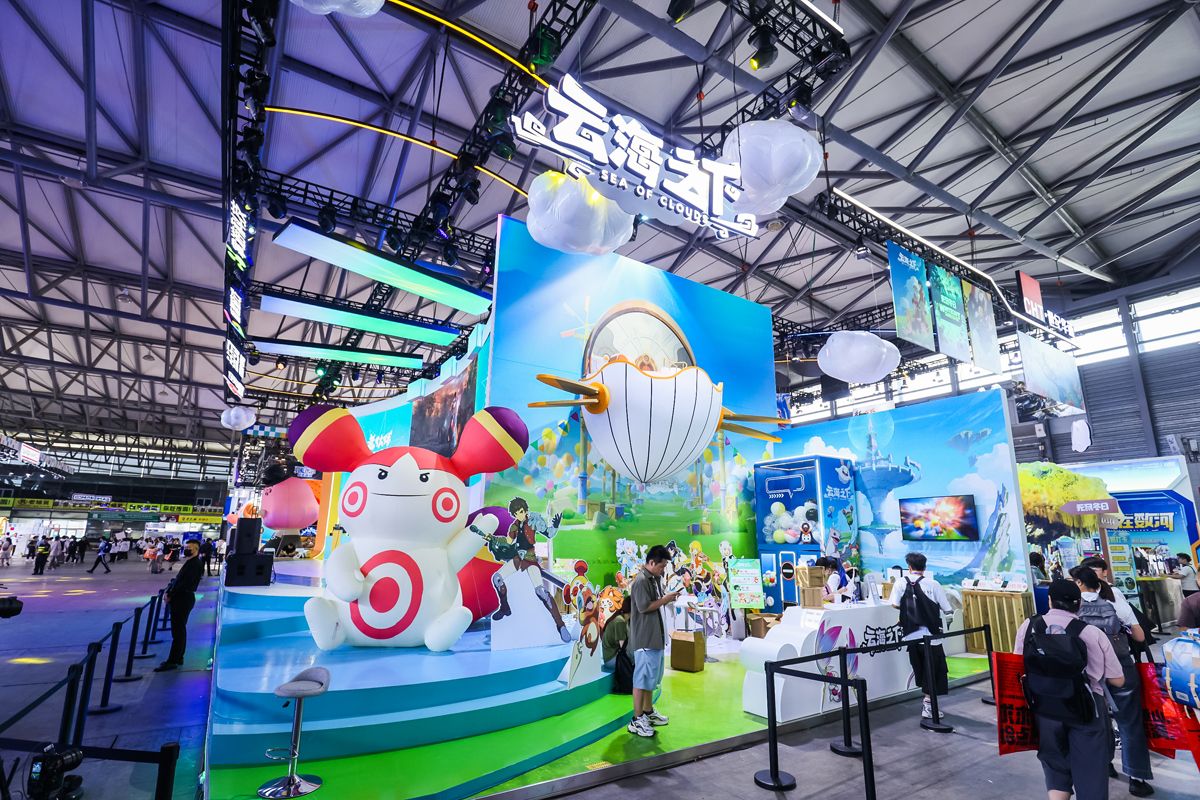 世纪华通2024ChinaJoy《云海之下》展台全景，中央摆放一张白色小床，周围玩家围观点评