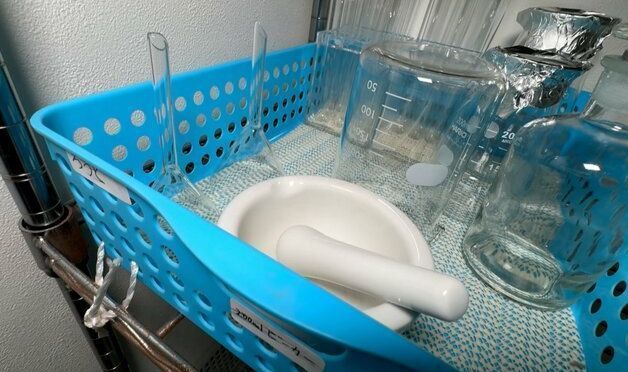 实验台上的化学试剂瓶整齐排列，标签清晰，部分正在发生颜色变化的反应