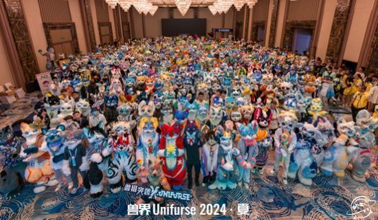 《兽猎突袭》展台位于全场中心位置，游戏角色立牌环绕，现场人流密集，气氛热烈