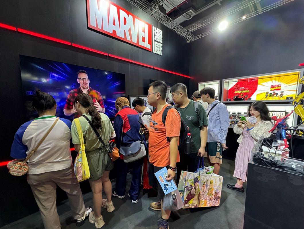 B站卡牌区UP主与玩家在展台进行《漫威终极逆转》对战，周围观众围观助阵