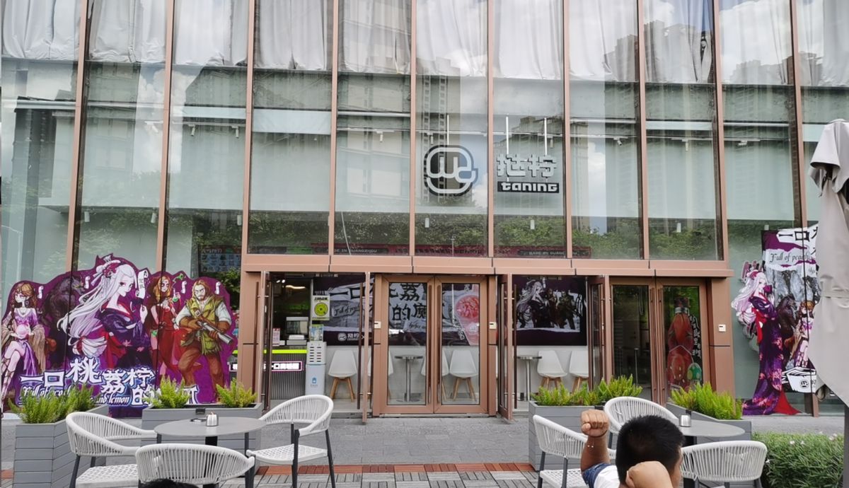 粉丝集体合影留念，手持联名饮品与周边，气氛热烈