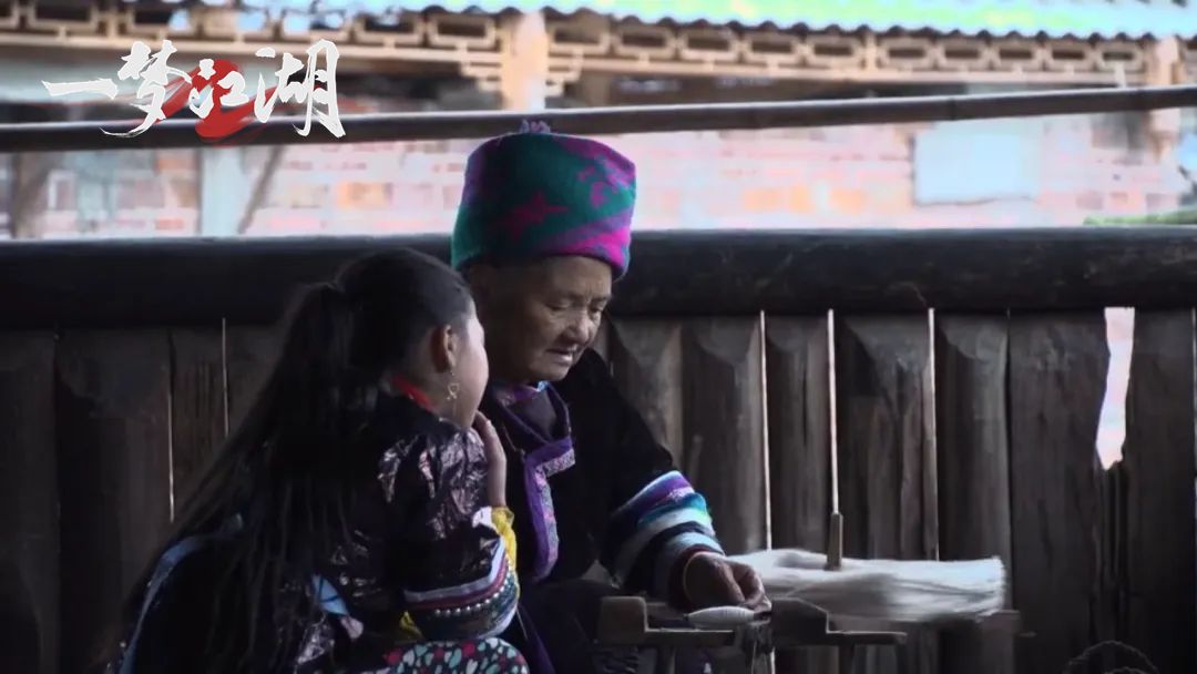 游戏内场景展示，少侠们围坐在侗寨火塘边，聆听NPC演唱侗族大歌，氛围温馨而庄重