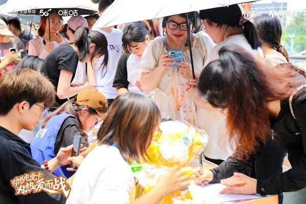 湘潭海选赛现场全景，观众席人山人海，舞台中央大屏显示‘动感电竞卡 为热爱而战’标语