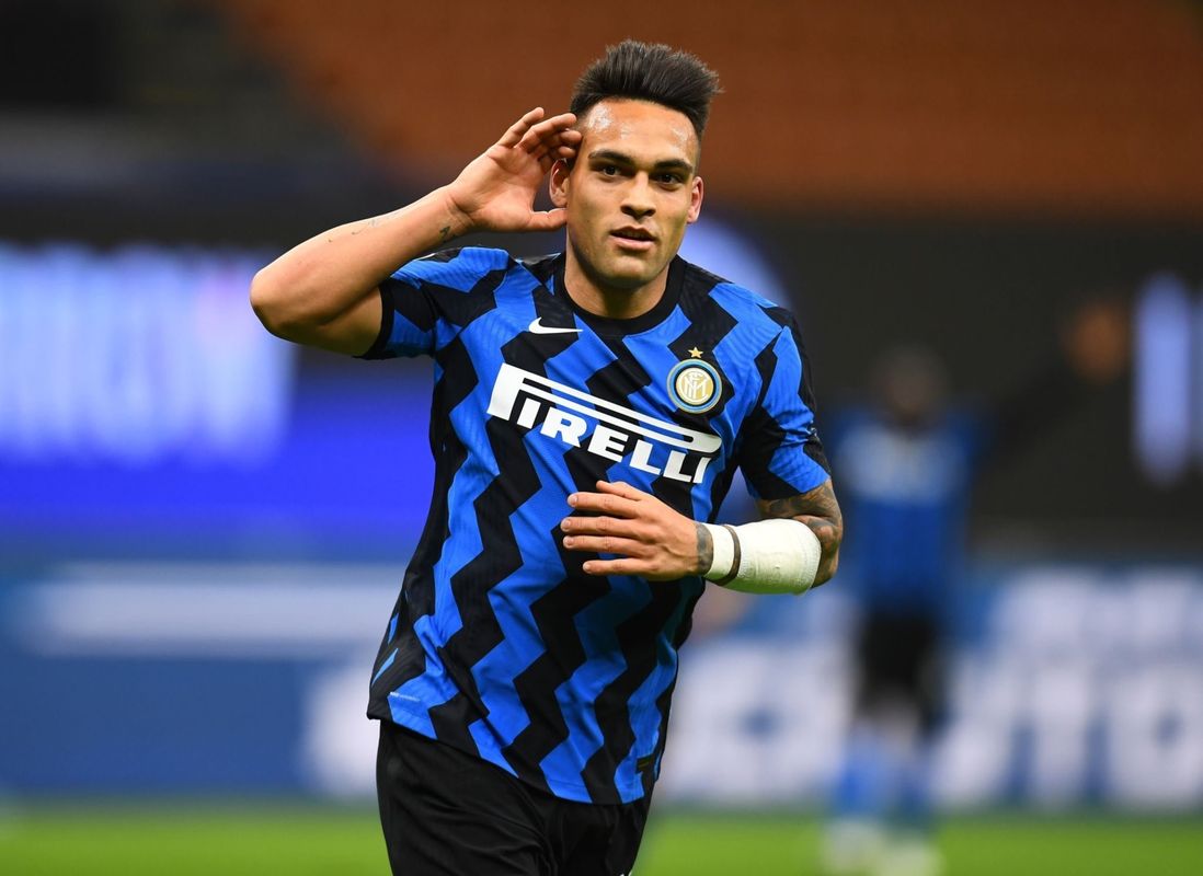 劳塔罗在国际米兰比赛中带球突破，身着蓝黑战袍，动作流畅，防守球员紧追不舍