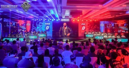 战队成员集体合影留念，身穿统一队服，手持战队旗帜，背景为赛事主题展板